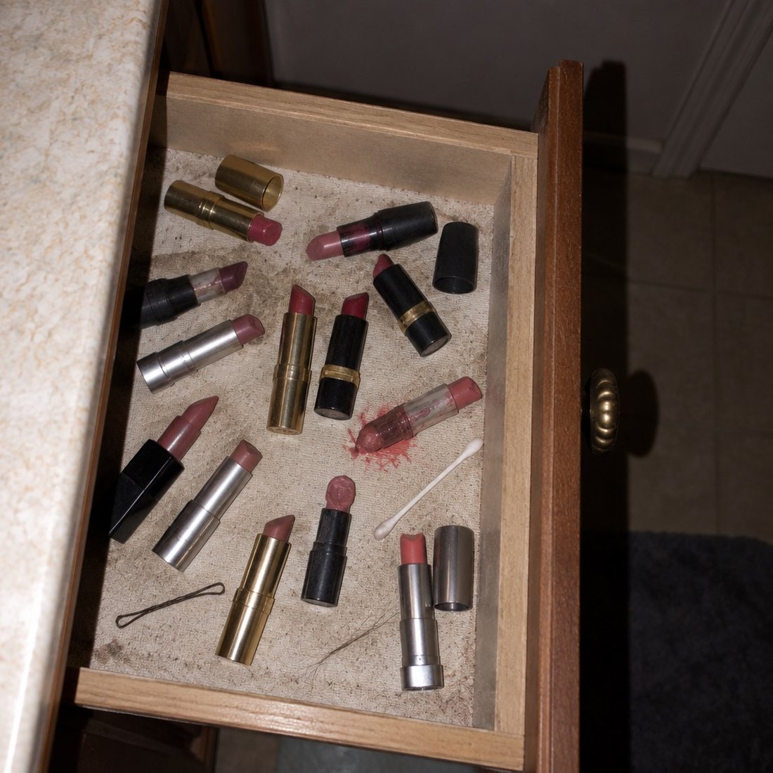 An open drawer holding a dozen part-used lipsticks